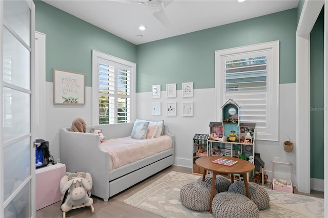 bedroom featuring ceiling fan, light wood-type flooring, and multiple windows