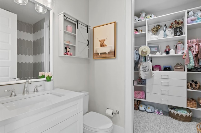 bathroom with tile patterned flooring, vanity, and toilet