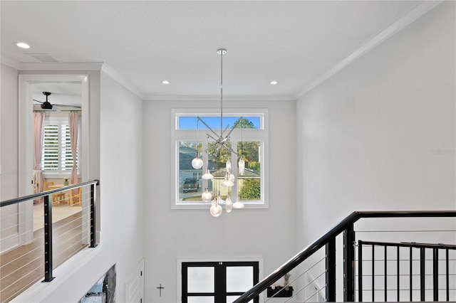 interior space featuring ceiling fan with notable chandelier and crown molding