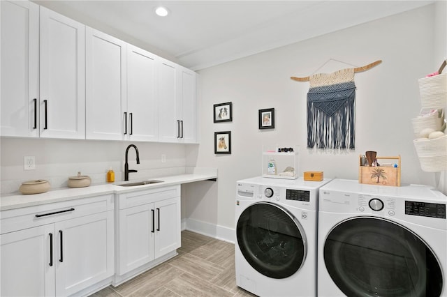 clothes washing area featuring washer and dryer, cabinets, and sink