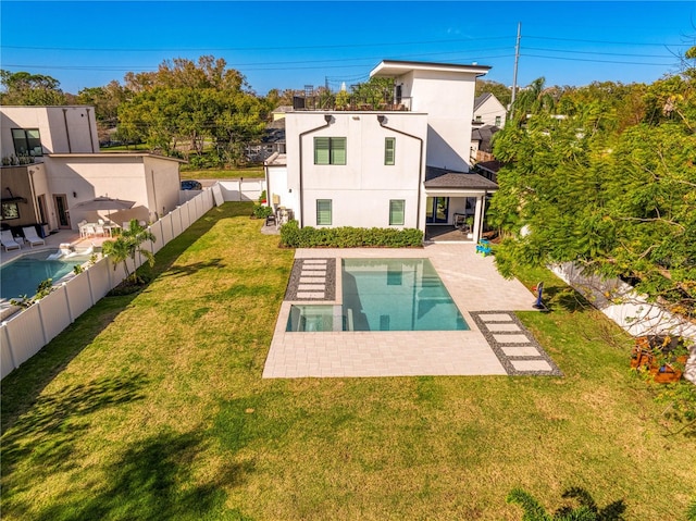 back of house featuring a yard, a patio, and a fenced in pool