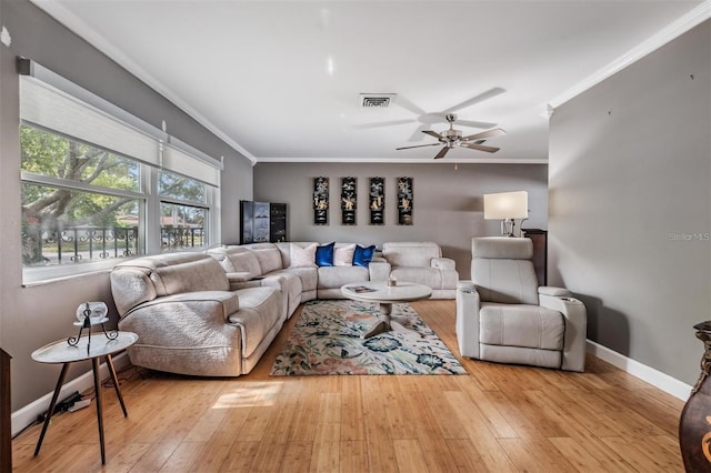 living room with light hardwood / wood-style floors, ceiling fan, and crown molding