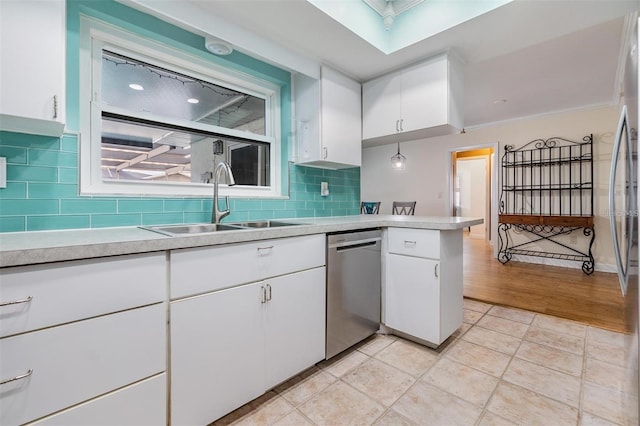 kitchen featuring dishwasher, white cabinets, sink, light hardwood / wood-style flooring, and decorative backsplash