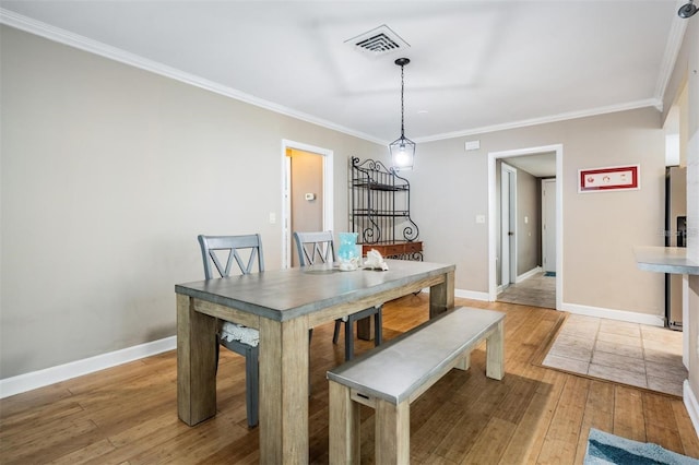 dining room featuring light wood-type flooring and ornamental molding