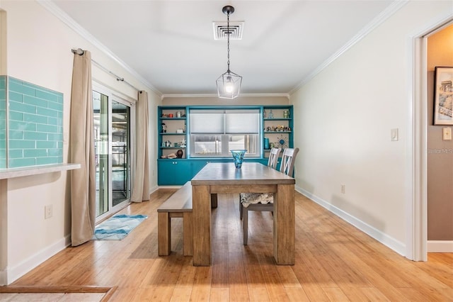 dining area featuring ornamental molding and light wood-type flooring