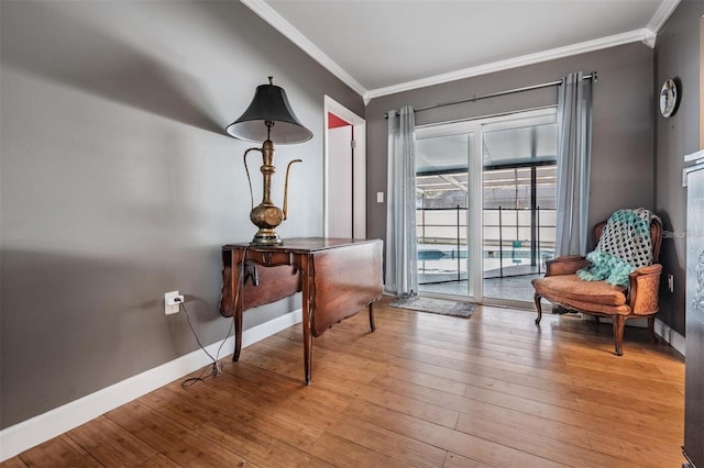 living area with light hardwood / wood-style flooring and ornamental molding