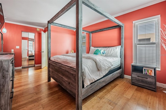 bedroom featuring light wood-type flooring and crown molding