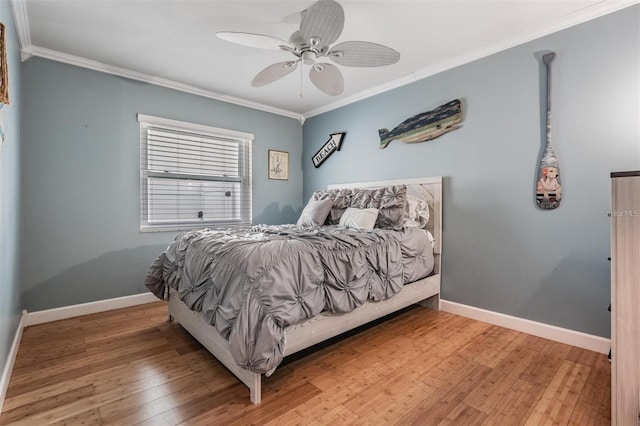 bedroom featuring hardwood / wood-style flooring, ceiling fan, and crown molding