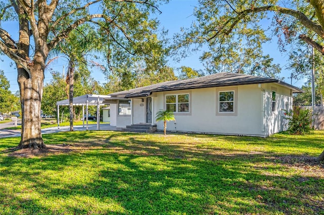 ranch-style house featuring a front yard and a carport