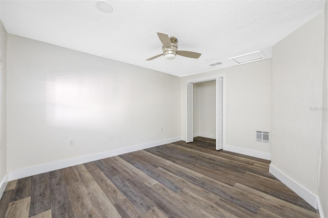 empty room featuring a textured ceiling, dark hardwood / wood-style floors, and ceiling fan