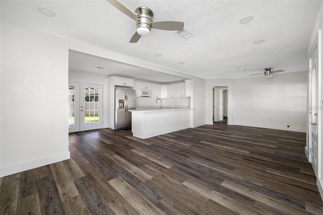 unfurnished living room featuring sink, ceiling fan, a textured ceiling, dark hardwood / wood-style flooring, and french doors