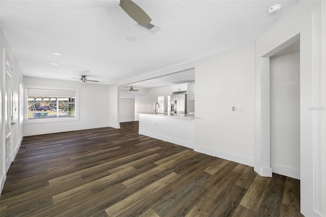 unfurnished living room with ceiling fan, dark hardwood / wood-style floors, and sink