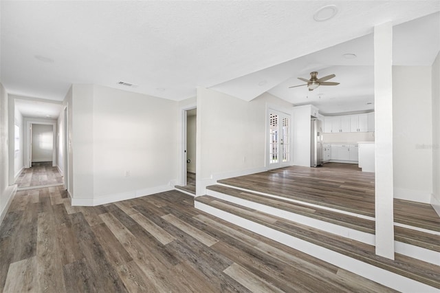 unfurnished living room with hardwood / wood-style flooring, ceiling fan, and a textured ceiling