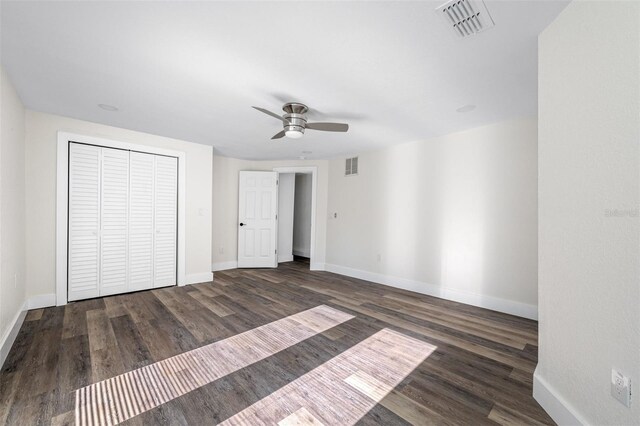 unfurnished bedroom featuring dark hardwood / wood-style floors, a closet, and ceiling fan