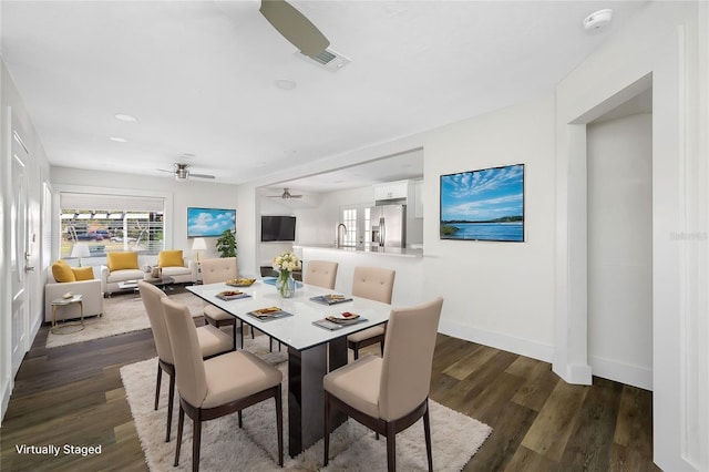 dining space with ceiling fan, dark hardwood / wood-style flooring, and sink