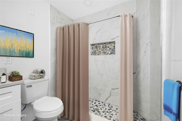 bathroom with a tile shower and toilet