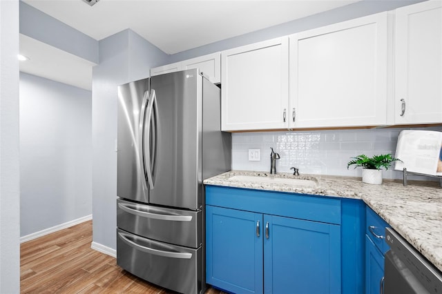 kitchen featuring white cabinets, blue cabinets, sink, light hardwood / wood-style floors, and stainless steel appliances