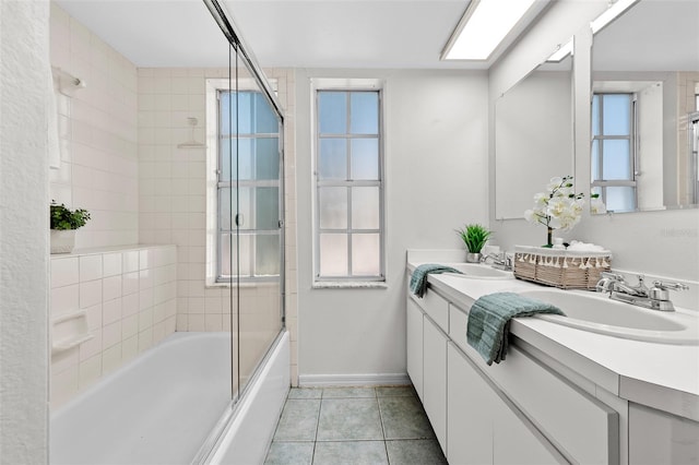 bathroom with tile patterned floors, shower / bath combination with glass door, vanity, and a skylight