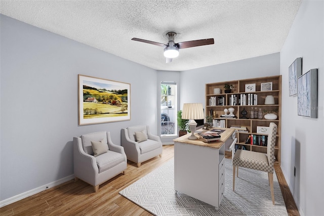 home office featuring a textured ceiling, light hardwood / wood-style flooring, and ceiling fan