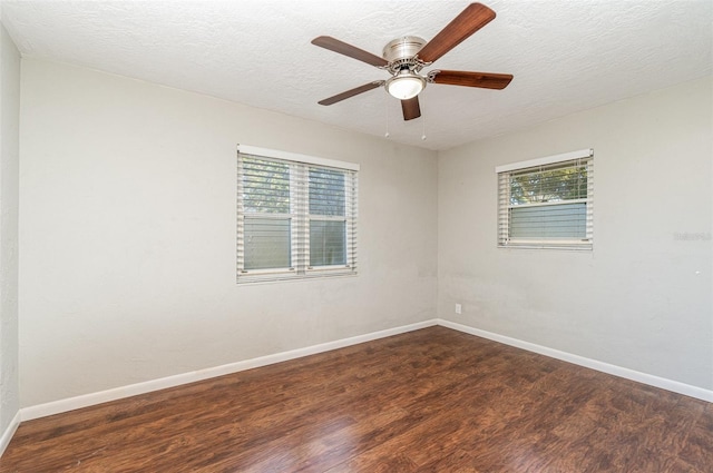 spare room featuring a textured ceiling, ceiling fan, and dark wood-type flooring