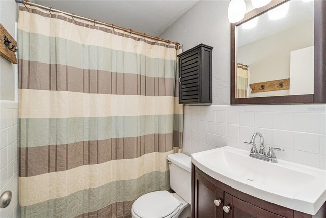 bathroom with vanity, backsplash, toilet, tile walls, and walk in shower