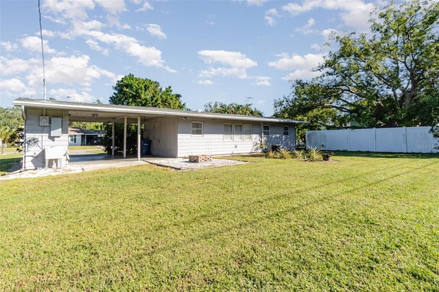 rear view of house featuring a yard and a carport