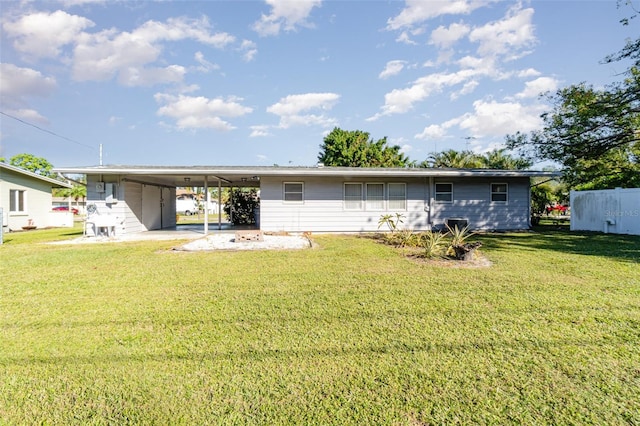 back of house featuring a lawn and a carport