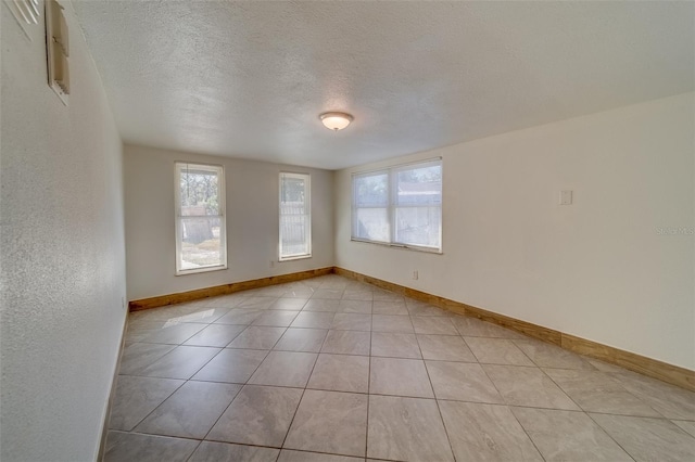 tiled spare room with a textured ceiling