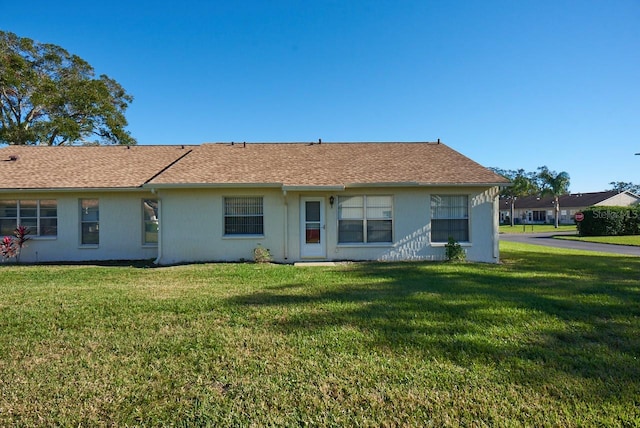 back of property with a lawn