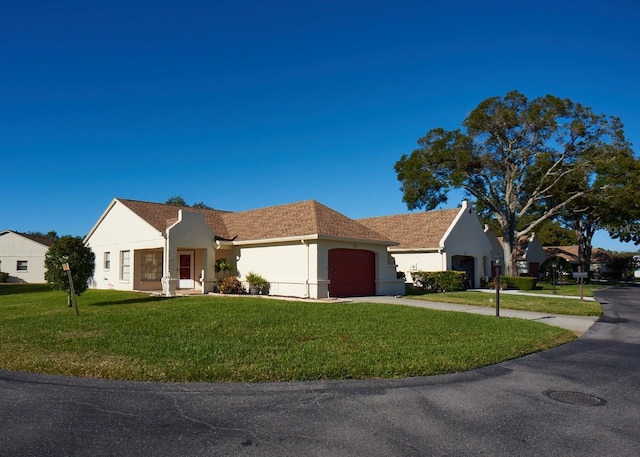 ranch-style house featuring a front yard and a garage