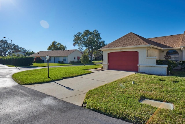 ranch-style house featuring a garage and a front lawn