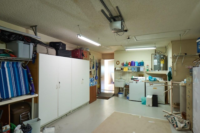 garage with independent washer and dryer, electric water heater, sink, and a garage door opener