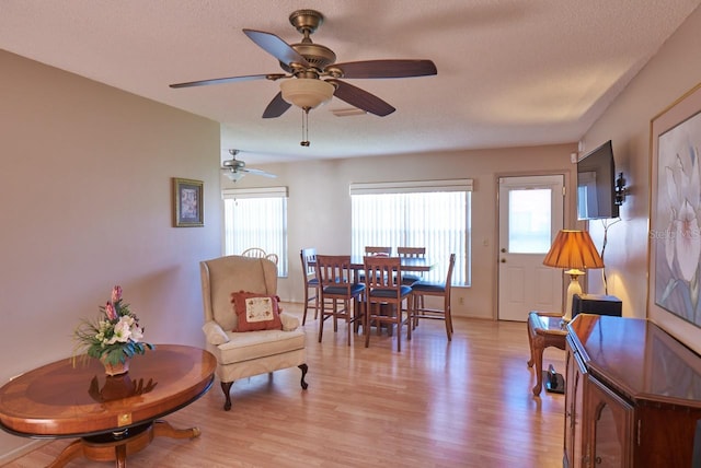 dining room with a textured ceiling, light hardwood / wood-style floors, and ceiling fan