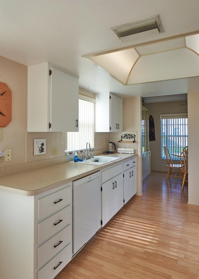 kitchen with white cabinets, dishwasher, and decorative backsplash