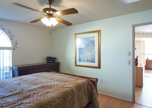 bedroom featuring a textured ceiling, light hardwood / wood-style flooring, and ceiling fan