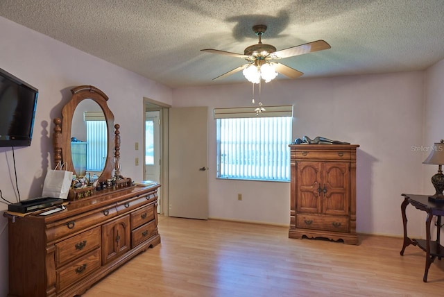 sitting room with ceiling fan, light hardwood / wood-style flooring, and a textured ceiling