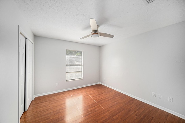 unfurnished bedroom featuring a closet, ceiling fan, a textured ceiling, and hardwood / wood-style flooring