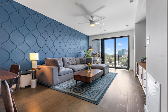 living room featuring ceiling fan and dark wood-type flooring