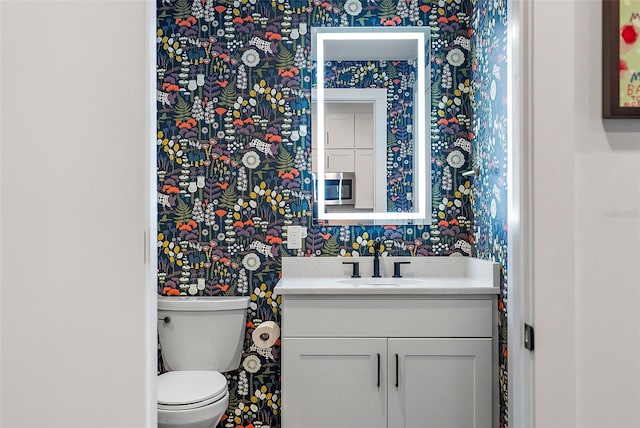 bathroom featuring toilet and vanity