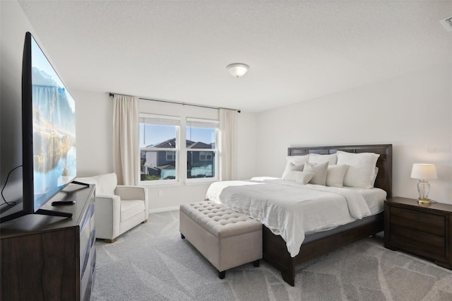 bedroom with a textured ceiling and light carpet