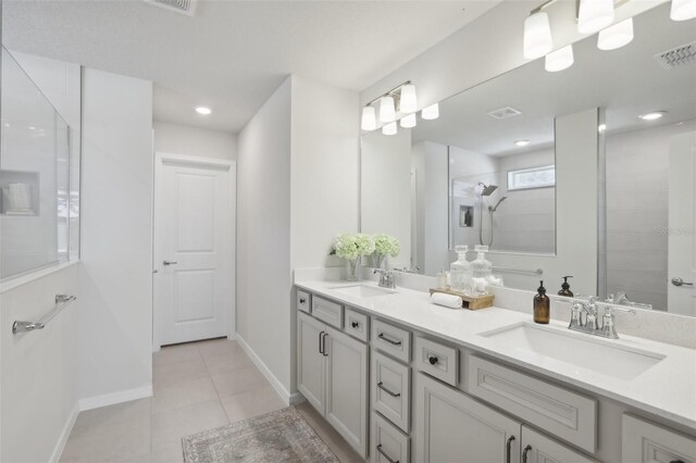 bathroom with tile patterned floors, vanity, and a tile shower