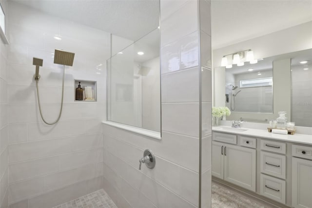 bathroom featuring a tile shower and vanity