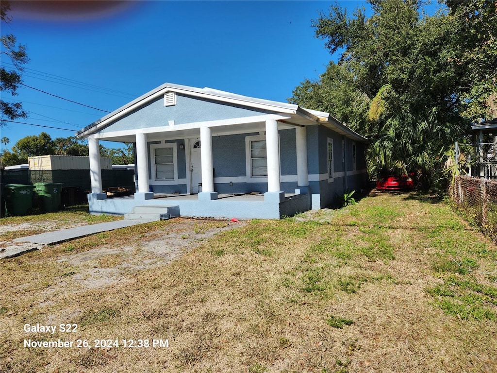 view of front of property featuring covered porch and a front lawn