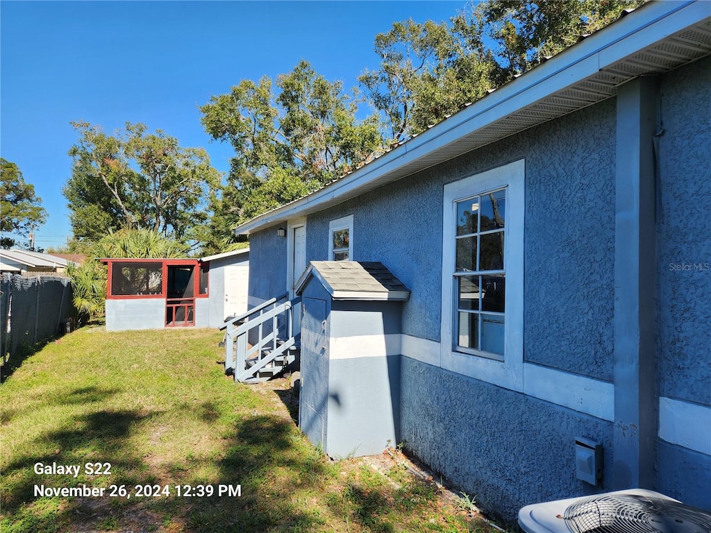 view of home's exterior featuring a lawn, central AC unit, and an outdoor structure