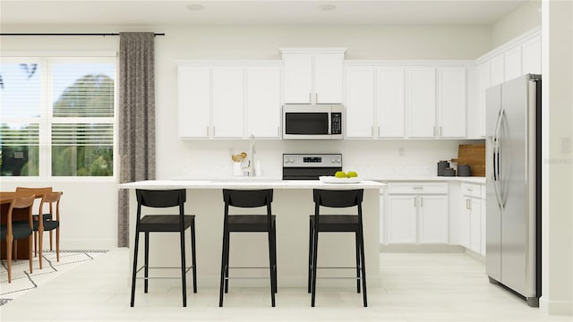 kitchen with a breakfast bar area, stainless steel fridge with ice dispenser, stove, and white cabinets