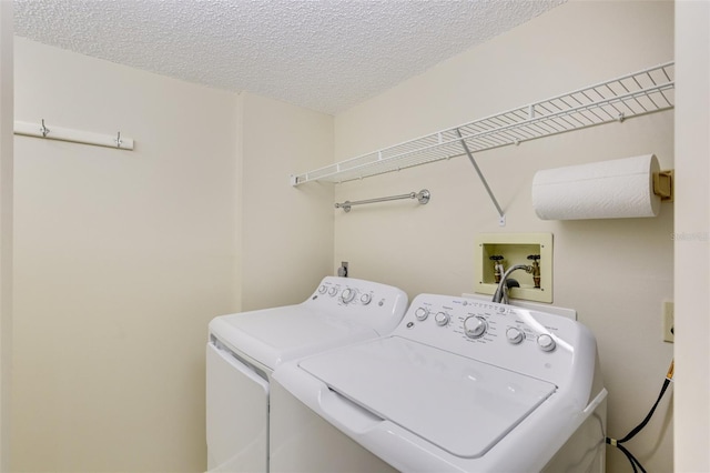 clothes washing area featuring a textured ceiling and washing machine and clothes dryer