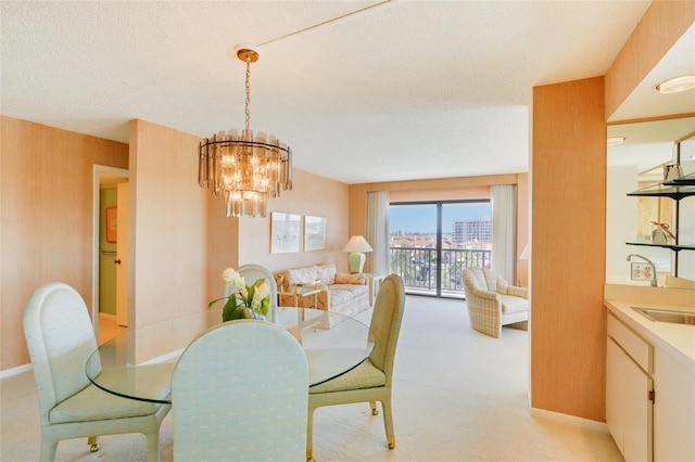 carpeted dining space featuring a chandelier and a textured ceiling