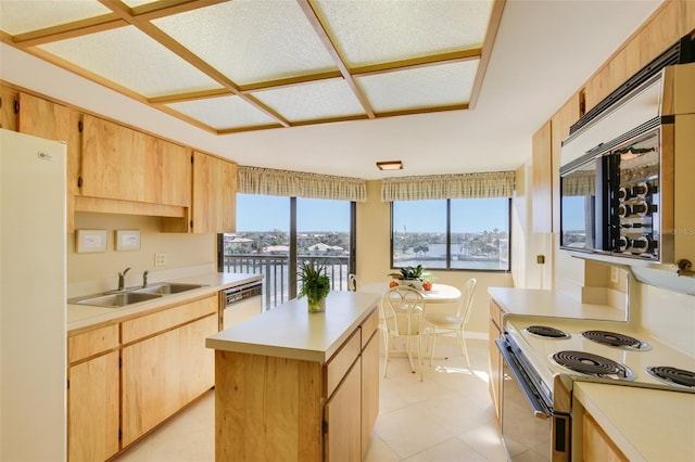 kitchen with light brown cabinets, white appliances, a kitchen island, and sink