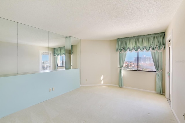 empty room with carpet floors and a textured ceiling