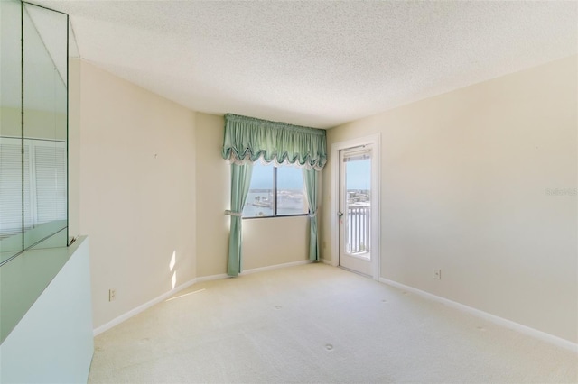 carpeted empty room featuring a textured ceiling